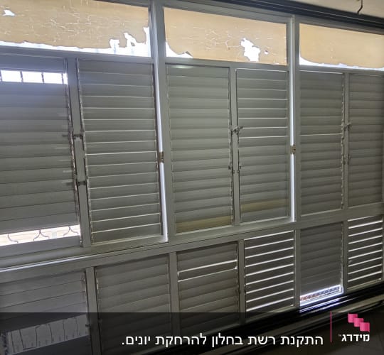 תריסים סגורים עם חלונות עליונים שבורים